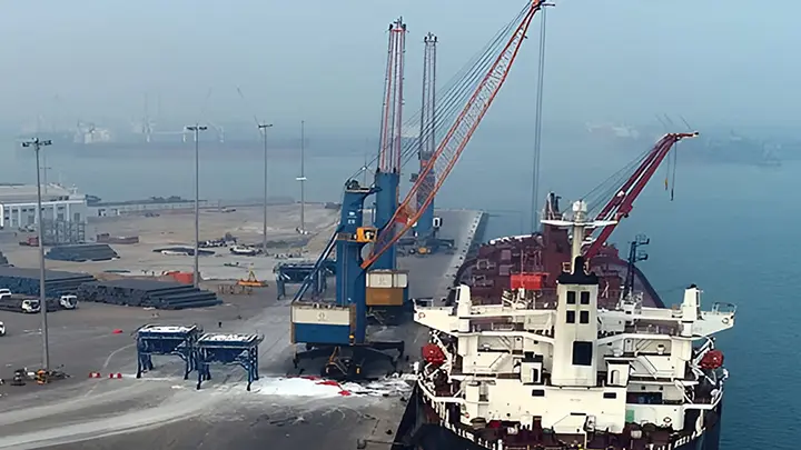 Modern container ship at port with shipping containers & cranes